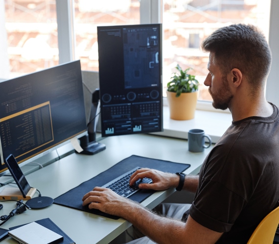 Man working at a multi-monitor desk setup