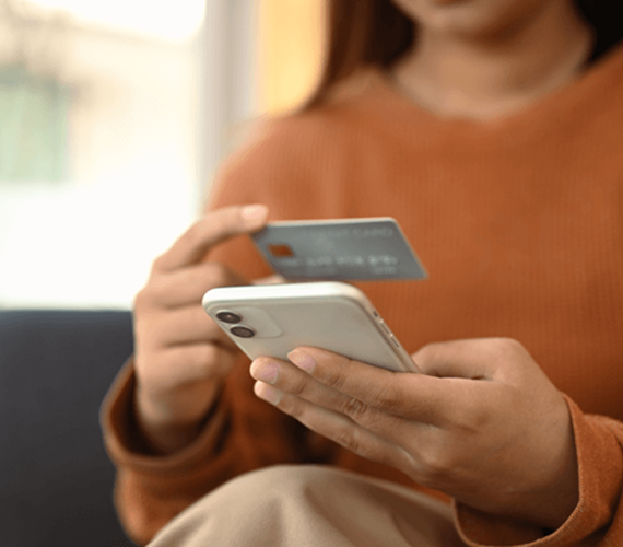Person holding a smartphone and credit card
